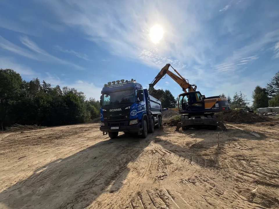Koparka kołowa Hyundai ładuje urobek na wywrotkę Scania RC-TRANS